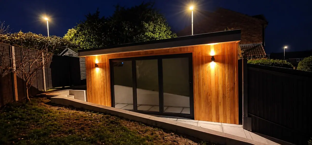 Illuminated timber garden room at dusk